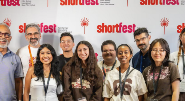 Students and faculty posing in front of a Shortfest step and repeat